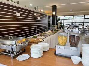 Uma mesa de buffet com diversos alimentos e utensílios.