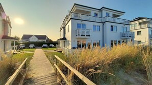 A multi-story residential building with a paved driveway leading to a gated entrance. - Doppelhaushalfte, Ostseeresort Olpenitz (Kappeln)