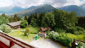 A mountain cabin with a view of snow-capped peaks, surrounded by dense forest and a small garden. - Chalet in Wildkogel Near Ski Slopes (Neukirchen am Grossvenediger)
