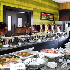 A buffet with labeled sections for cake, fruit salad, butter, and chicken. - Prodis Hotel and Suites (Sagamu)