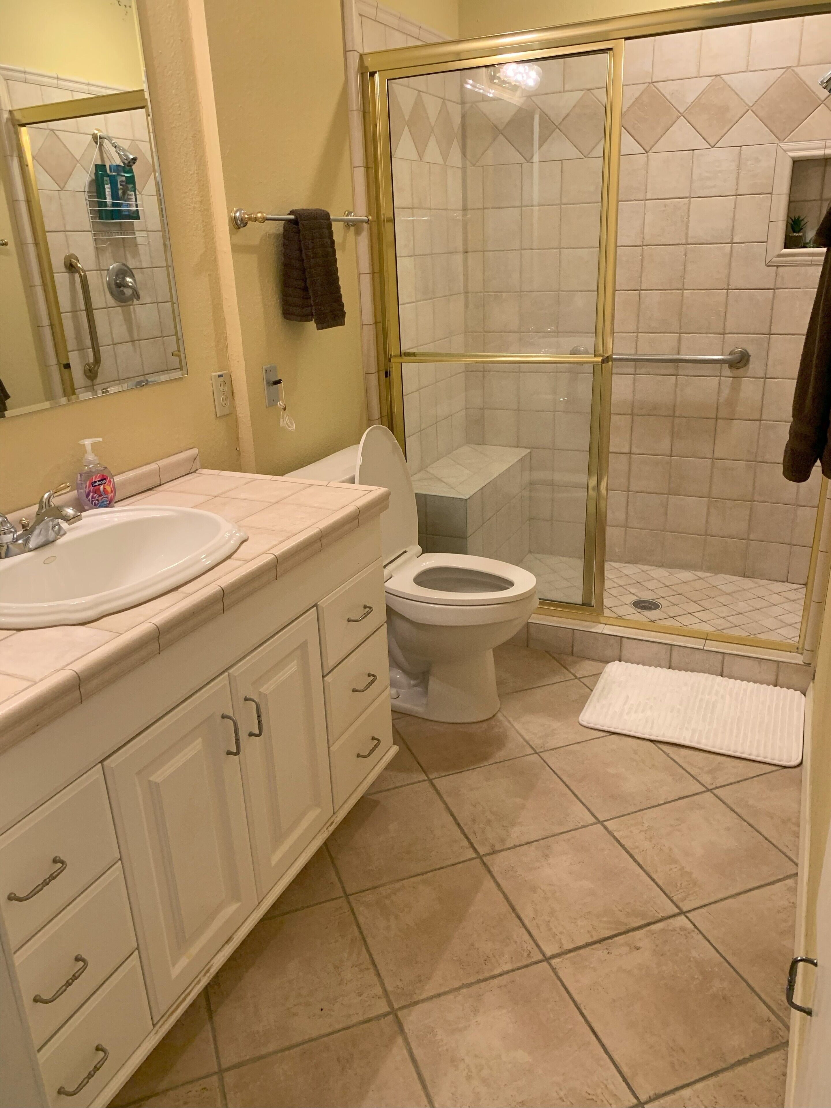 A bathroom with a white sink, toilet, and shower area.