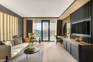 Luksussuite, balkong, utsikt mot innsjø | Senger med overmadrass, minibar, safe på rommet og individuelt dekorert