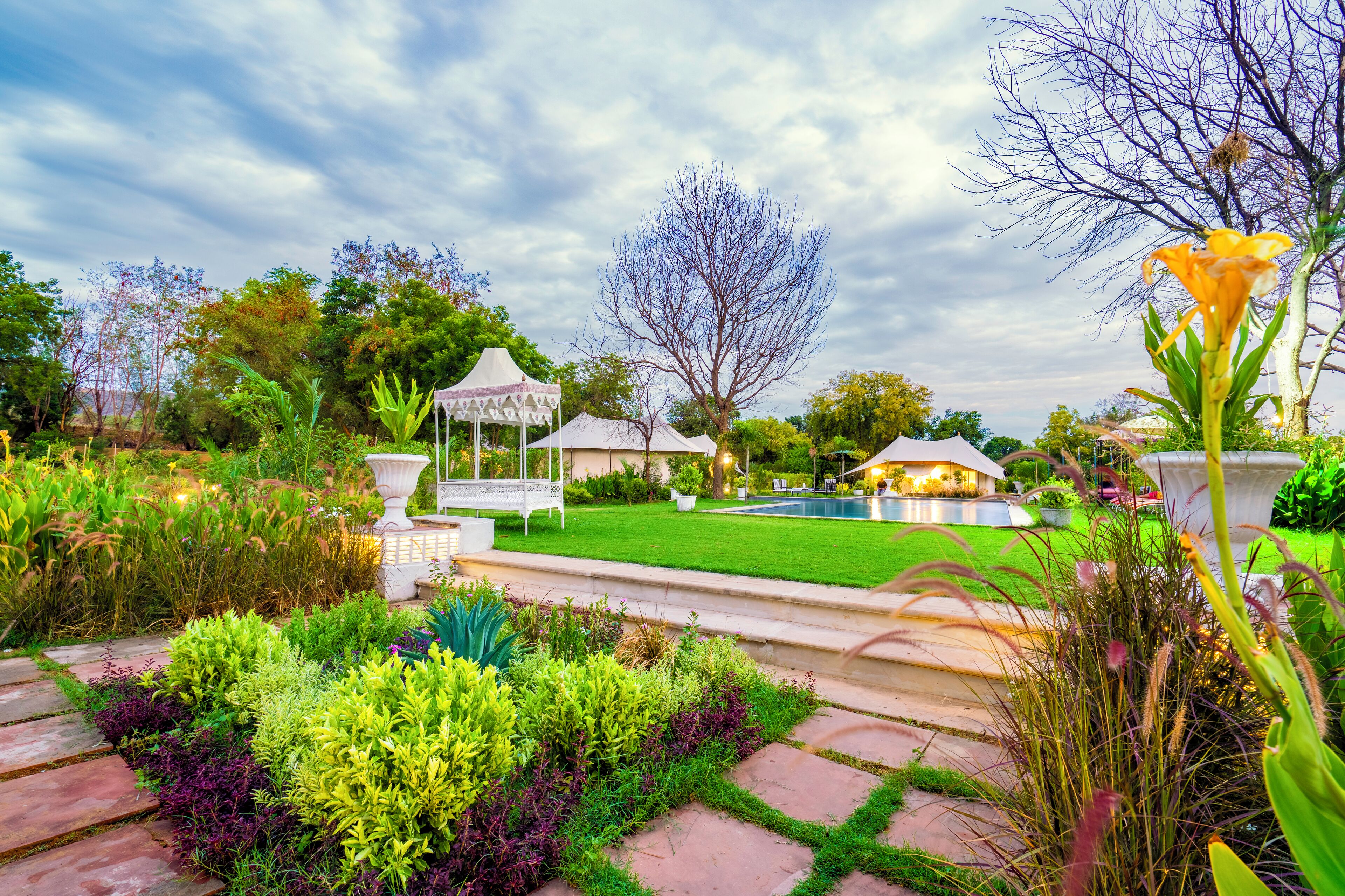 A well-maintained garden with a lawn, a gazebo, and a swimming pool.
