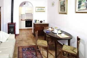 Un espacio habitable compacto con kitchenette, comedor y cama.