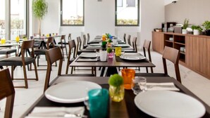 A modern dining area with multiple tables, chairs, and a view of the outdoors through large windows. - Villa in Rovinj Near Beach & Old Town (Rovinj)
