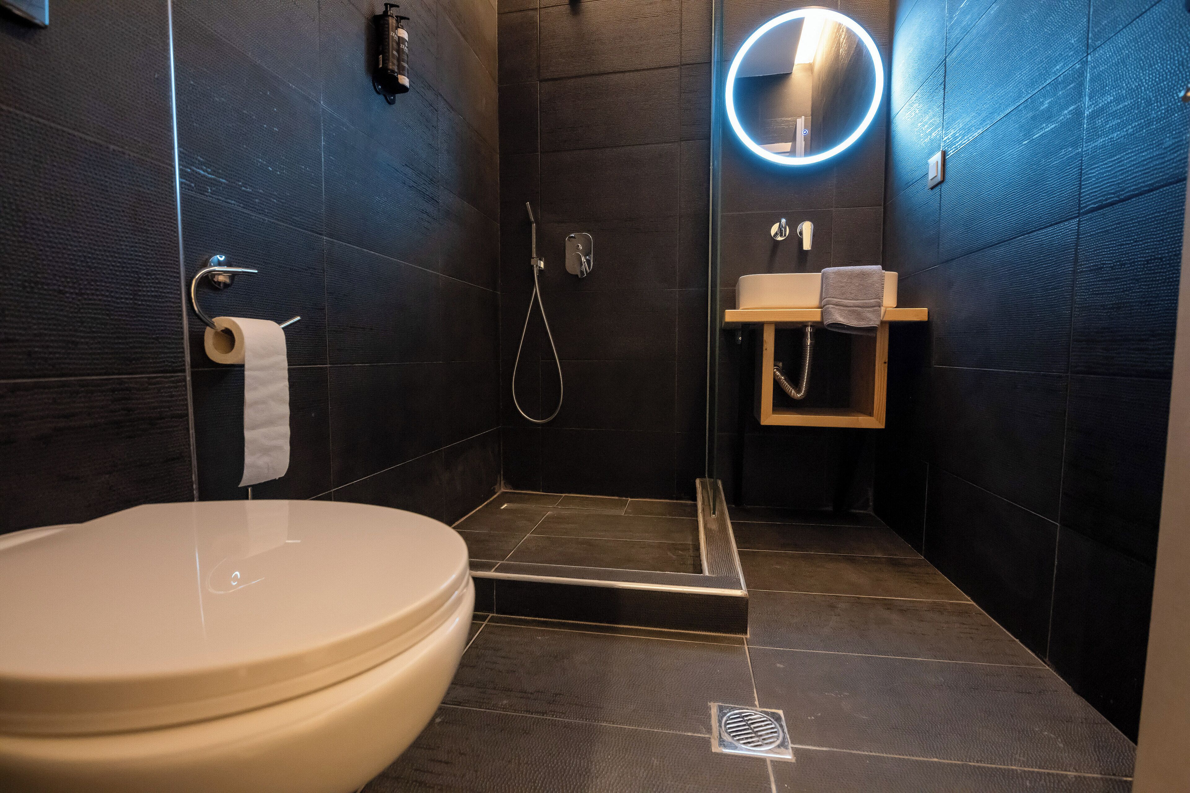 Un baño moderno con inodoro, ducha y lavamanos.