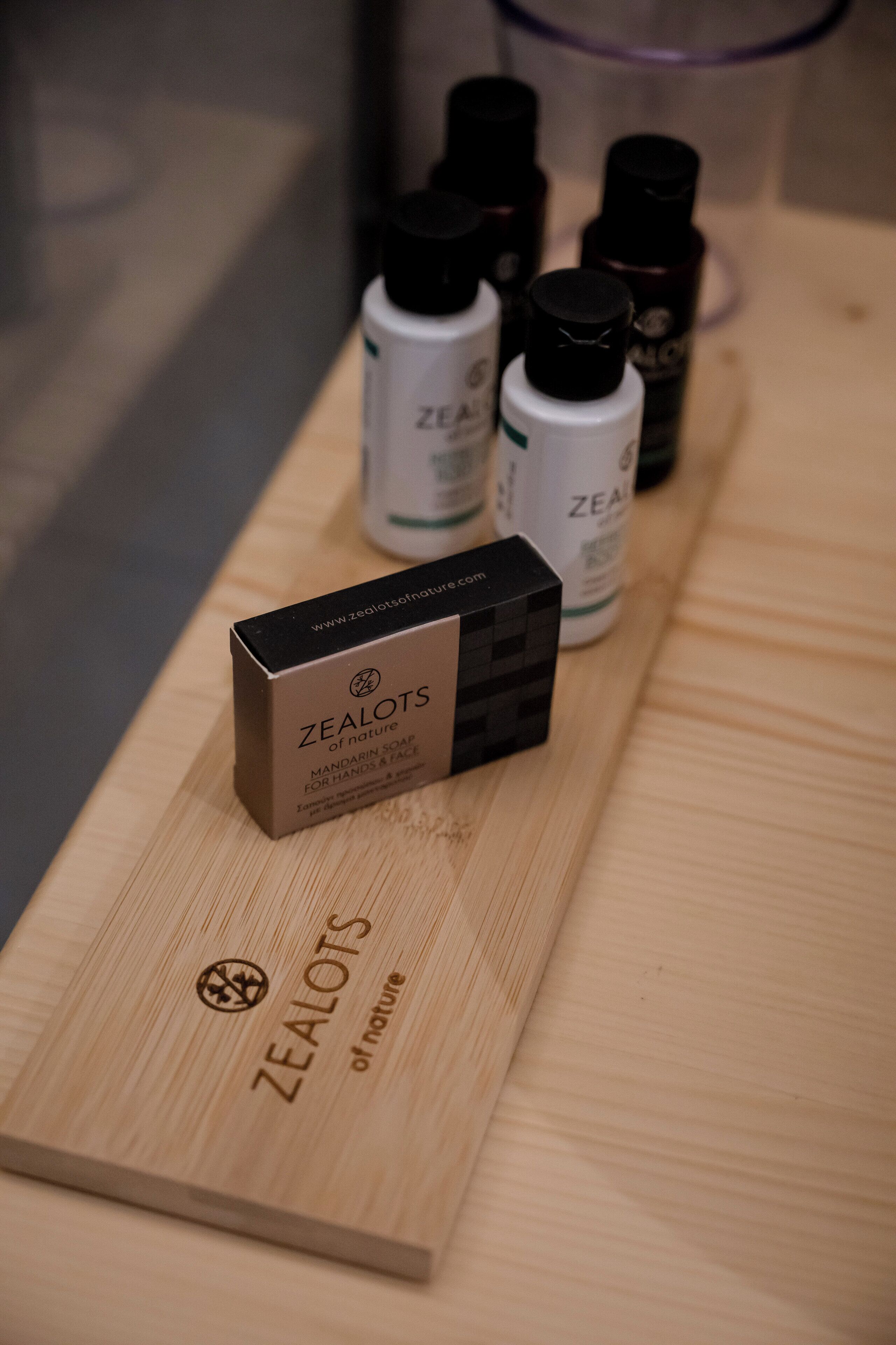A wooden surface with a box labeled 'ZEALOTS of nature' and several bottles of skincare products.