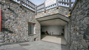 Un bâtiment en pierre doté d’un balcon en bois et d’une enseigne indiquant qu’il s’agit d’un établissement typique où l’on produit du salami et de la bresaola.