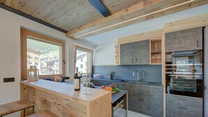 Een moderne keuken met houten kastjes, een centraal eiland en uitzicht naar buiten.