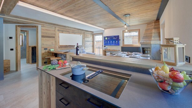 Een moderne keuken met houten details, een centraal eiland met een spoelbak en een fruitschaal.