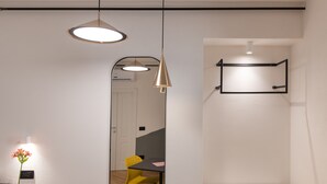 Et moderne værelse med skrivebord, stol og hængende lamper.