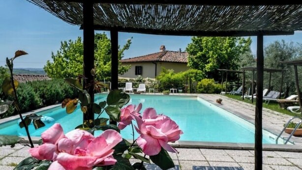 A pool area with a pergola, lounge chairs, and a house in the background. - Deliziosa Camera in Agriturismo a 7 km da Firenze (Toscana)