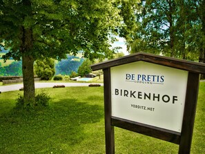 A sign for 'De Pretis Lodging' in Birkenhof with a view of a green landscape and a pool in the background. - Farmhouse in Nockberge Near Ski Slopes (Treffen)