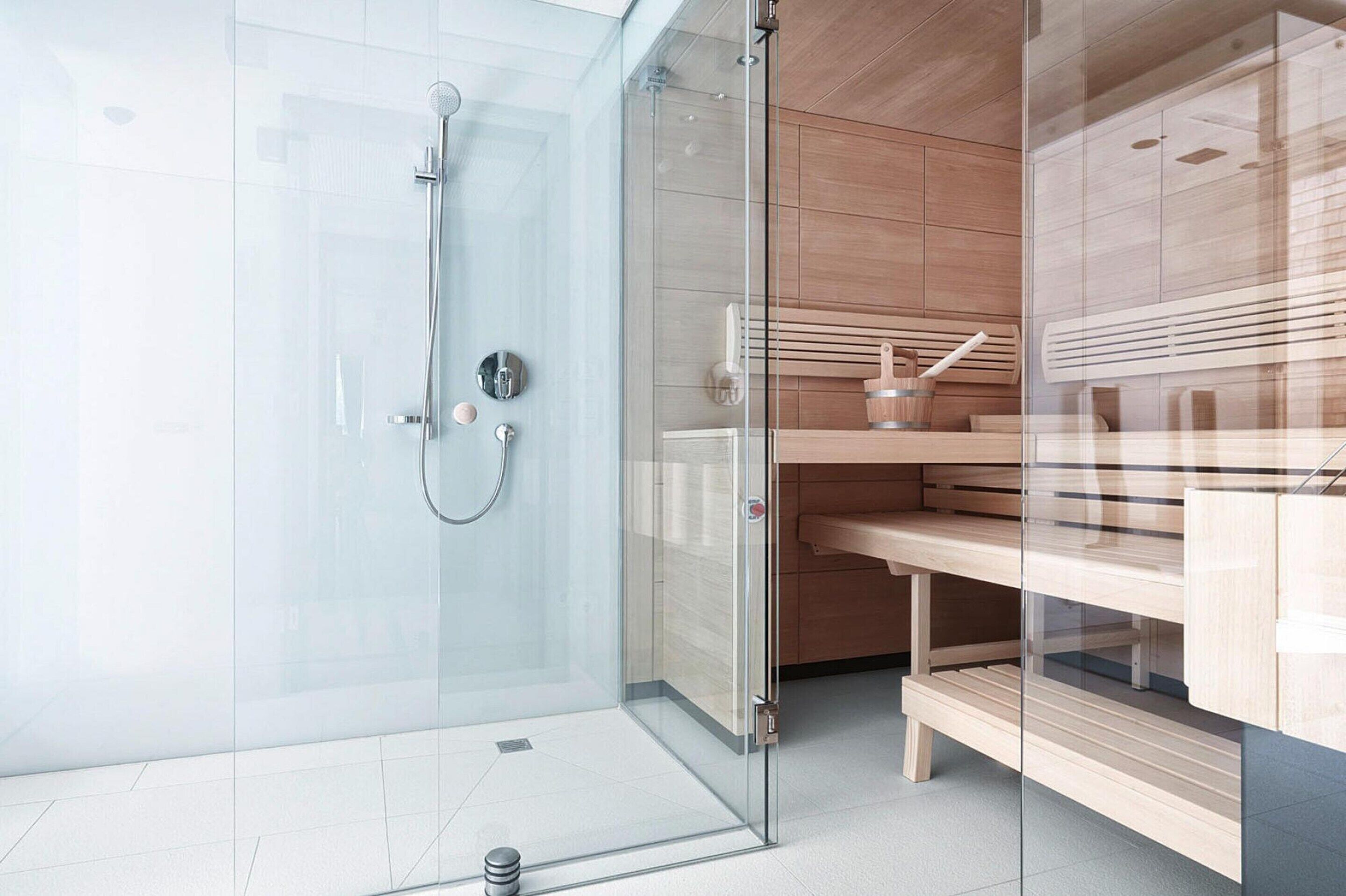 Un baño moderno con ducha de vidrio, muebles de madera y diseño minimalista.