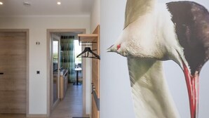 A hallway with a wooden floor, a bench, and a wall-mounted coat rack. - Penthouse am Nordstrand auf dem Deich (Nordstrand)