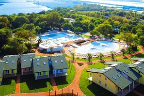 Vue aérienne d’un complexe hôtelier doté de plusieurs piscines, d’une fontaine centrale et de différents bâtiments aux toits plats.