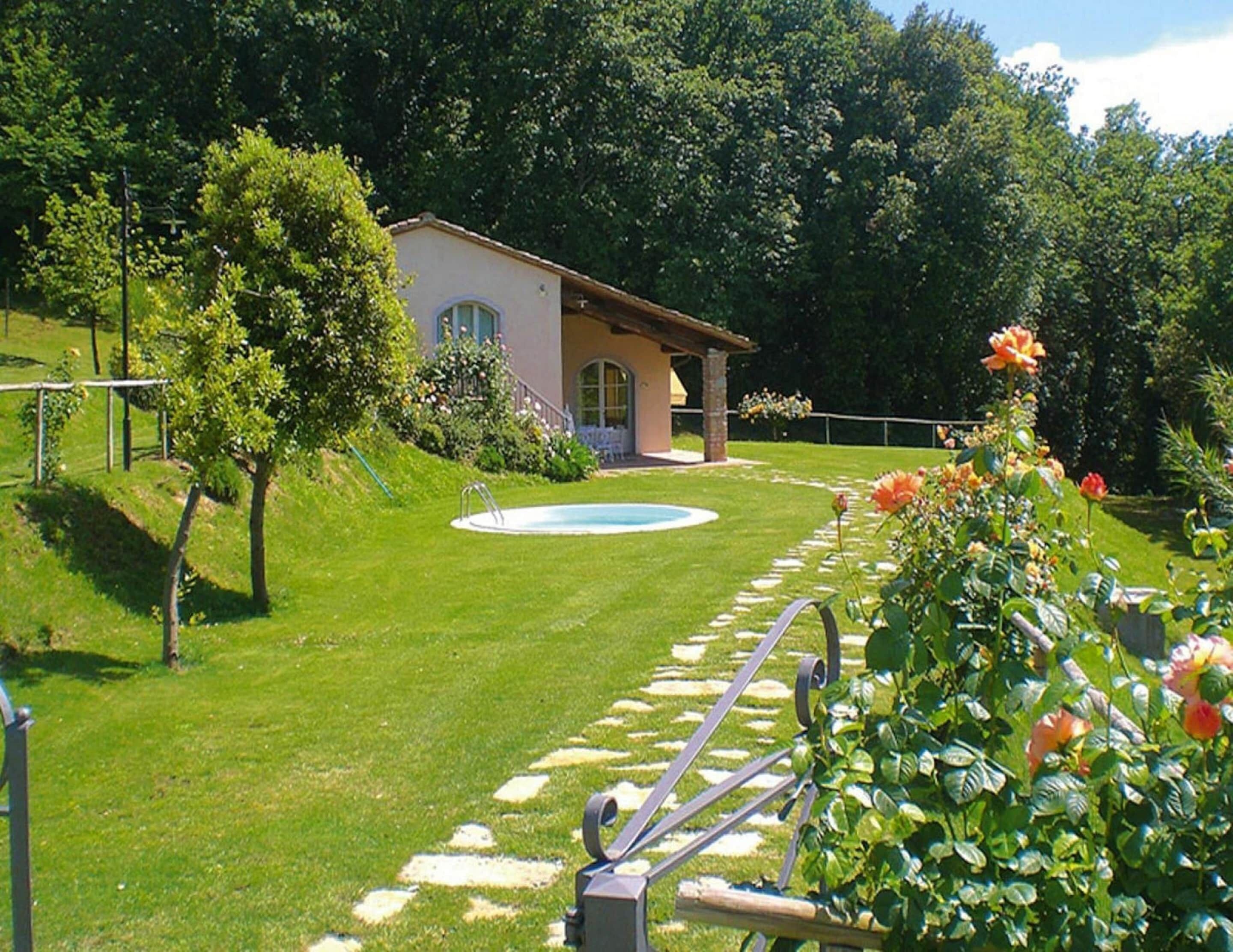 Una casa con piscina, rodeada de césped y jardín bien cuidados.