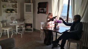 A cozy living room with a dining table, chairs, and a view of the outdoors. - Romantic studio apartment with a view (Toscana)