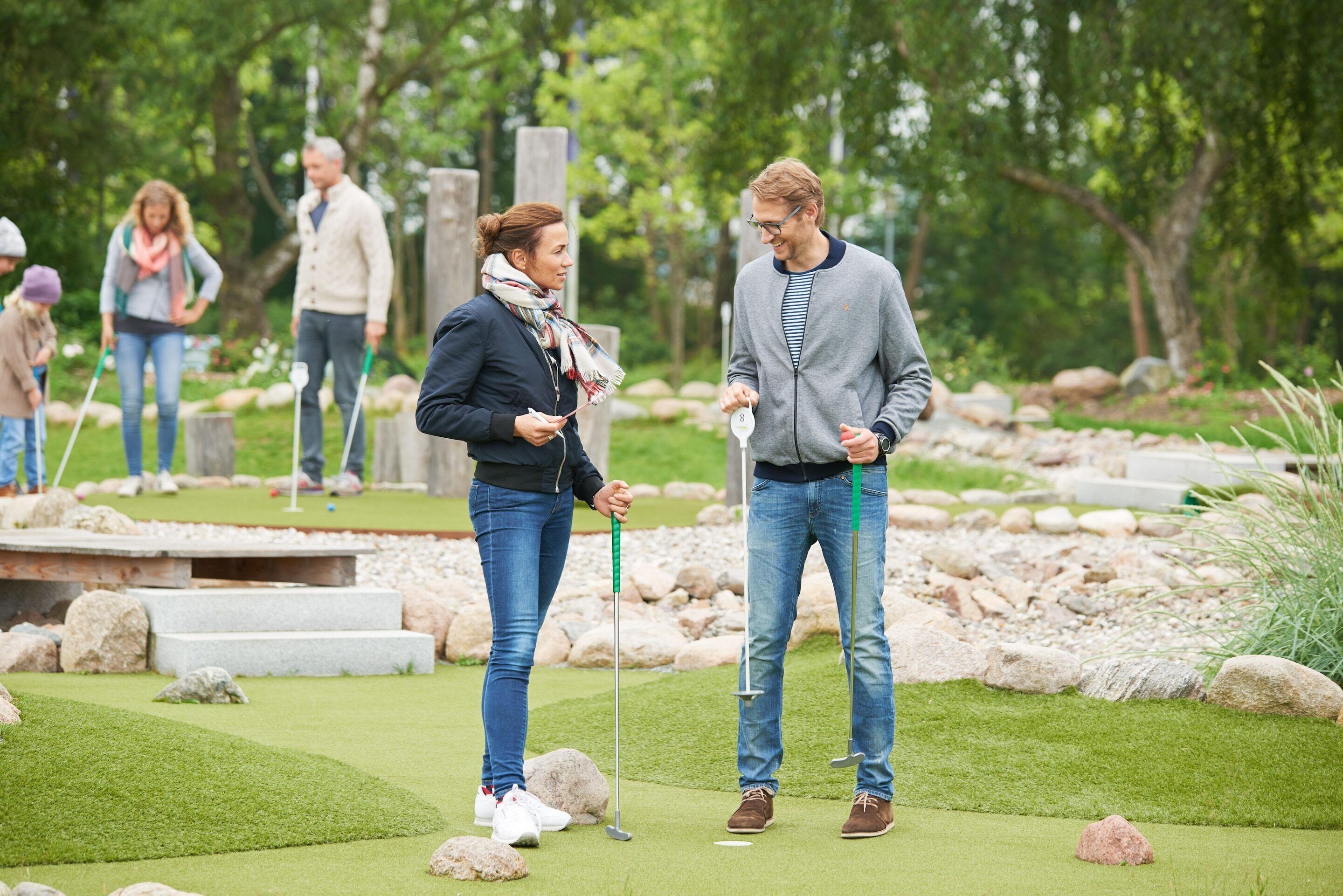 En golfbane med spillere og et putting green.