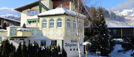 A hotel with a snow-covered roof and a mountain view.