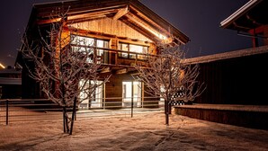 Eine Holzhütte mit Balkon, umgeben von Schnee.
