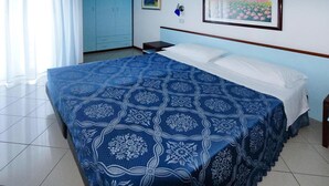 Ein Schlafzimmer mit einem großen Bett, einem Nachttisch, einem Kleiderschrank und zwei gerahmten Bildern an der Wand.