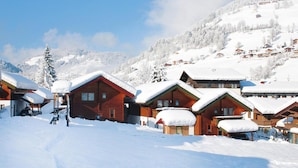 A snow-covered village with wooden cabins and a mountain backdrop. - Chalet in Kitzbuhel Alps Near Hiking Trails (Wildschönau)