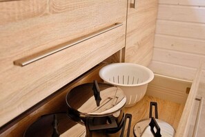 A kitchen with wooden cabinets, a colander, and a stove. - Holiday Home Pobierowo Near Baltic Beach (Rewal)