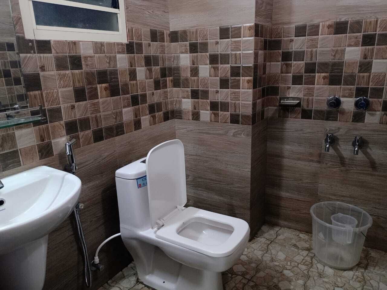 A bathroom with a toilet, sink, and shower area.