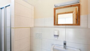 A bathroom with a toilet, sink, and mirror. - Komfortable Wohnung in Lubben an der Spree (Lübben (Spreewald))