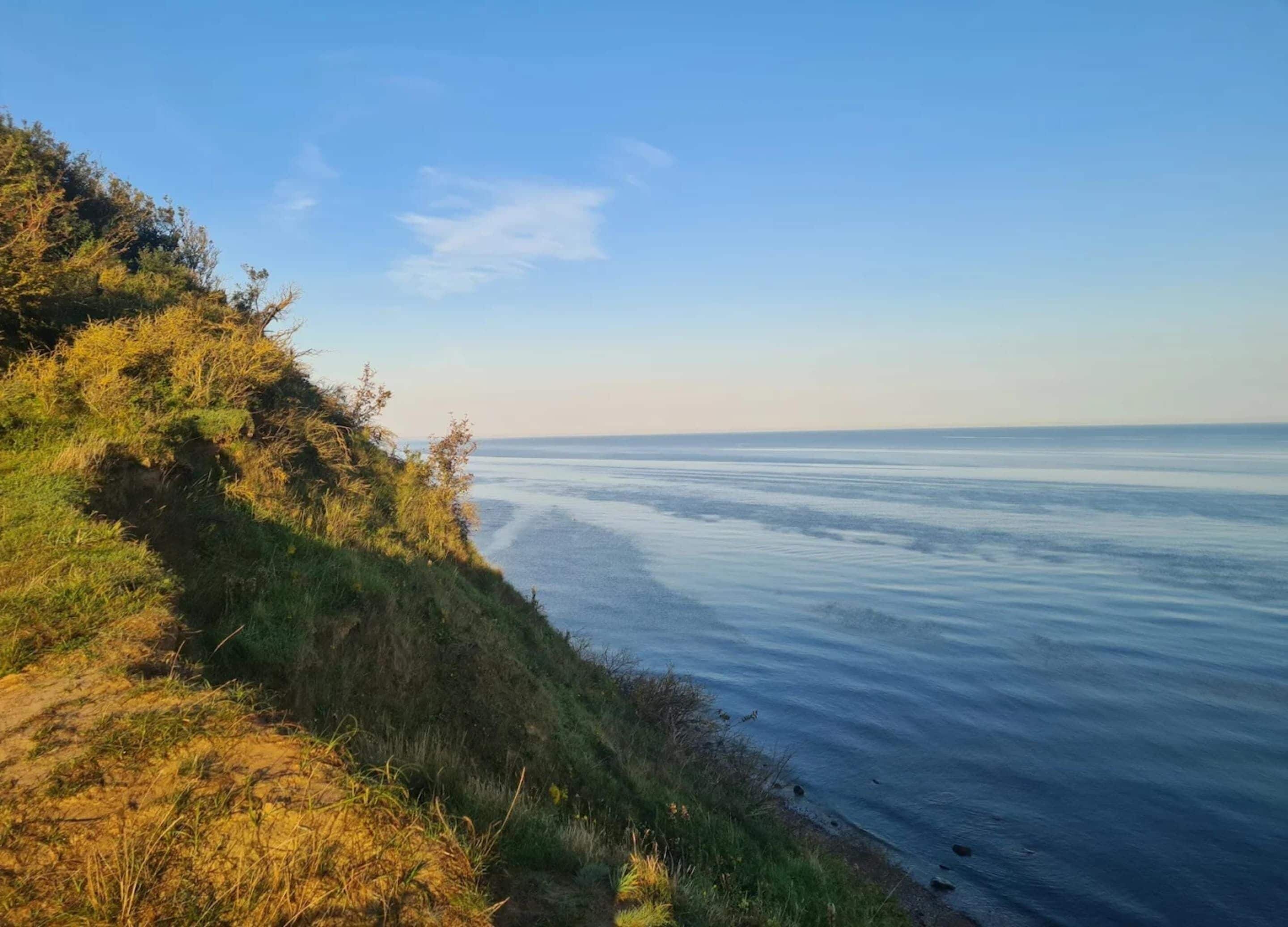 Un paysage côtier avec un ciel dégagé et une vue sur la mer.