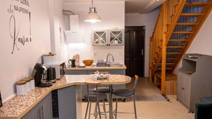 A compact kitchen with a central island, a sink, and a dining area with two chairs. - Apartment in Pobierowo Near Baltic Beach (Rewal)