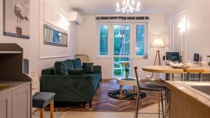 A modern living room with a sofa, a dining table, and a kitchen area. - Apartment in Pobierowo Near Baltic Beach (Rewal)