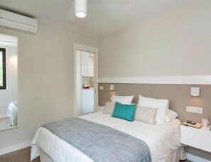 A bedroom with a bed, bedside table, and a nightstand.
