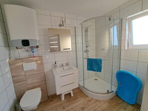 A modern bathroom with a glass-enclosed shower, a white sink, and a toilet. - Holiday Home in Niechorze Near Lighthouse (Rewal)
