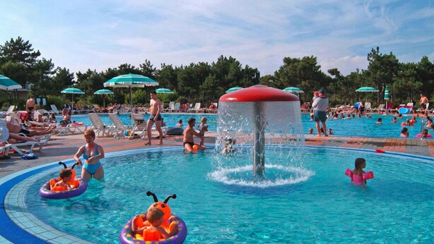 Une piscine avec plusieurs couloirs de nage, entourée de chaises longues et de parasols.