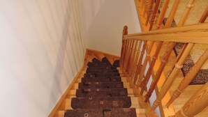 A wooden staircase with a handrail and a carpeted landing. - Kolczewo Cottage With BBQ & Garden (gmina Wolin)