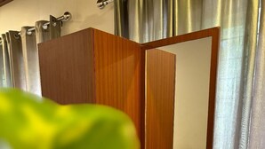 Una habitación con un armario de madera, un espejo y una cama.