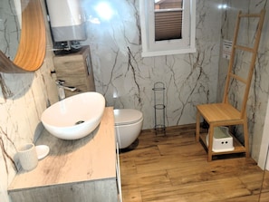 A bathroom with a white sink, toilet, and wooden floor. - Comfortable Holiday Homes, Close to the sea (Dziwnów)