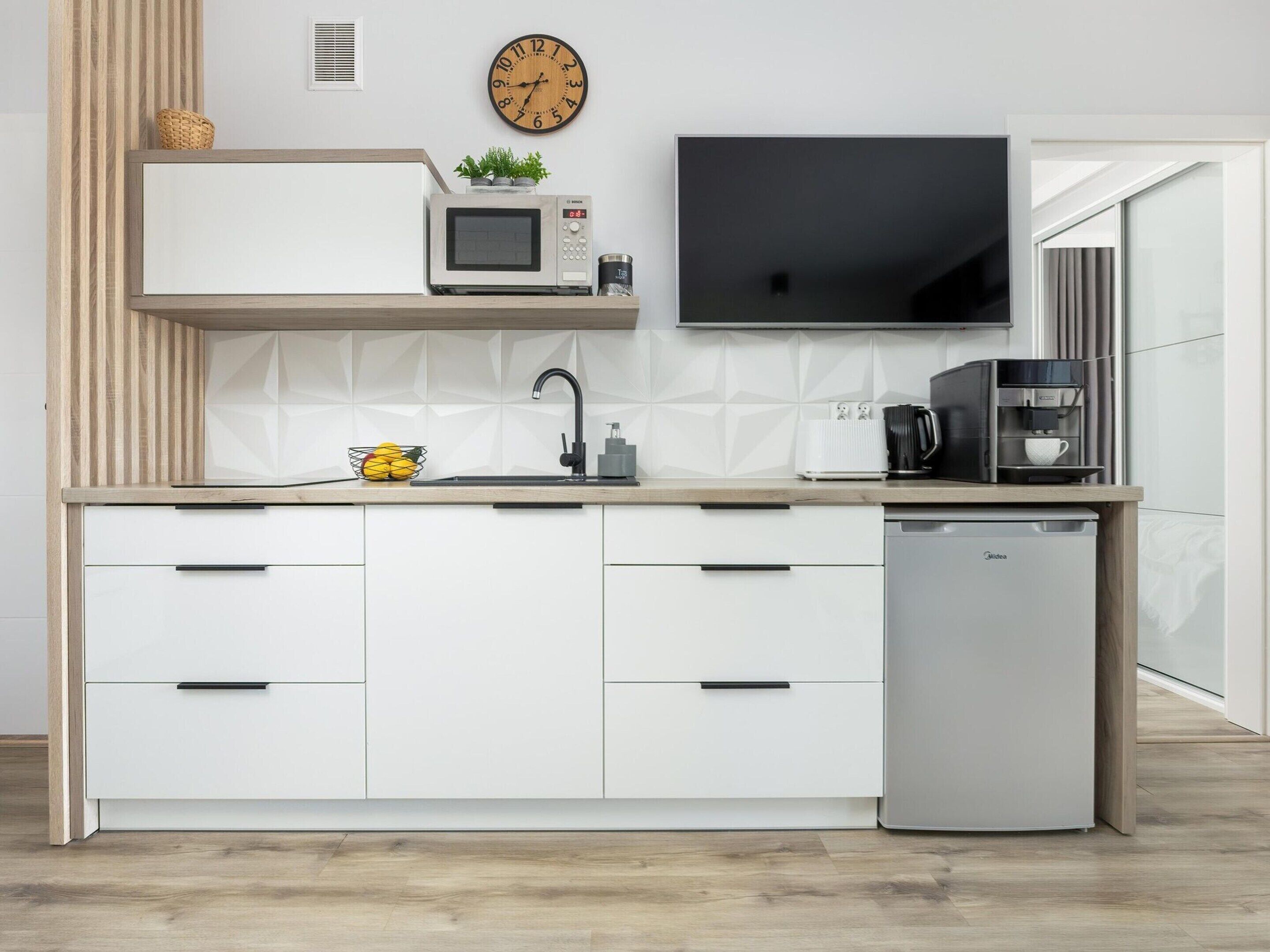 A modern kitchen with a built-in microwave, a coffee machine, and a dishwasher.