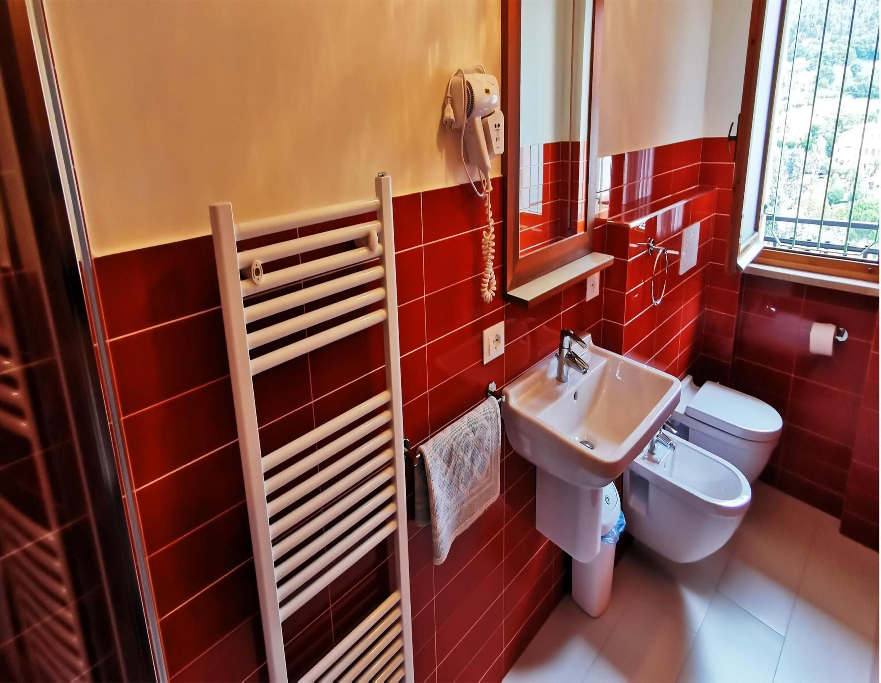 A bathroom with a white sink, a toilet, and a towel rack.