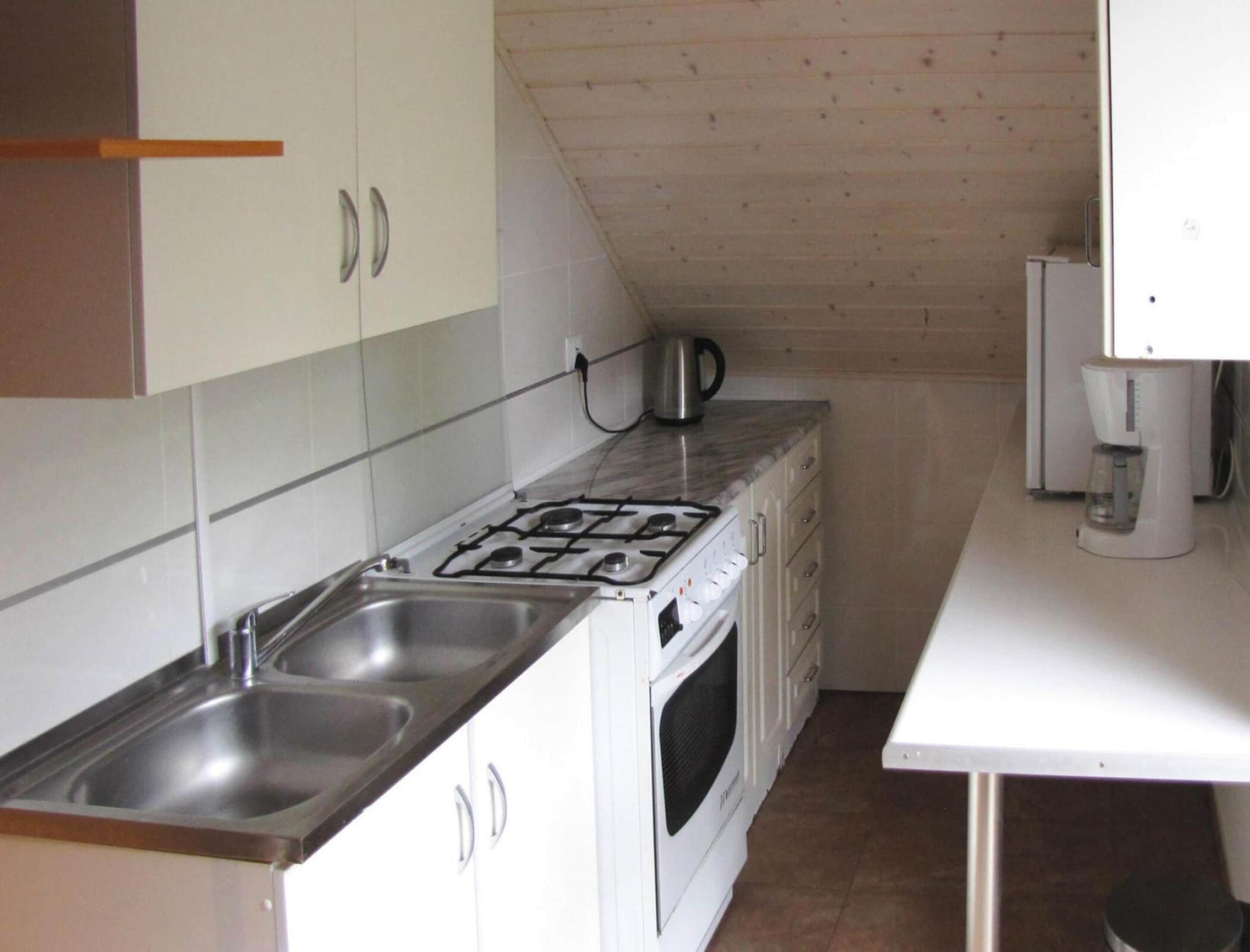 A kitchen with a gas stove, two sinks, a coffee maker, and a microwave.