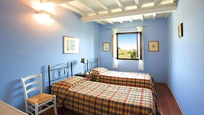Una camera da letto con due letti, una sedia e una finestra con vista.