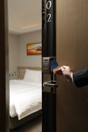 A hand inserting a card into a hotel room door lock. - Elysion Place Hotel Causeway Bay (Hong Kong)