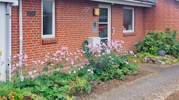 A red brick house with a garden in front.