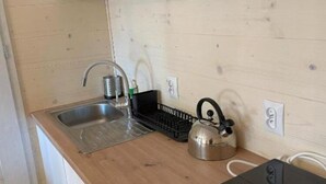 A small kitchen with a sink, kettle, and a black appliance on the counter. - New Houses Available Near the sea in Dziwnowek (Dziwnów)