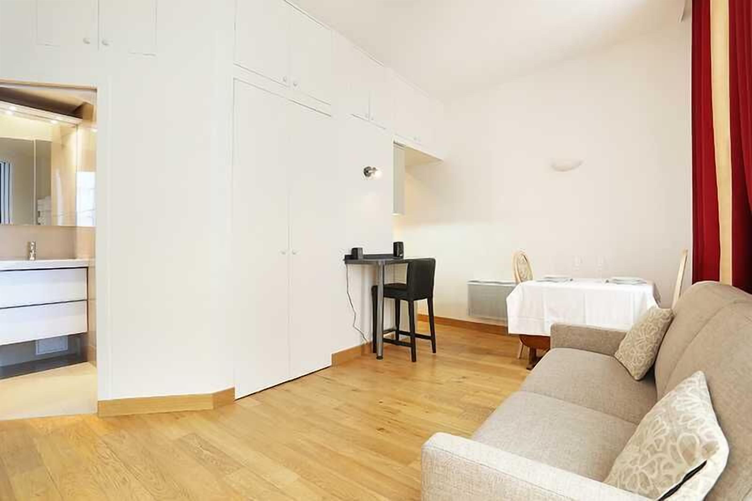 A compact living space with a kitchenette, a dining area, and a sofa.
