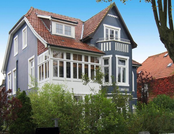 A two-story house with a red-tiled roof, white window frames, and a balcony. - Appartement, Wyk auf Fohr (Wyk auf Foehr)