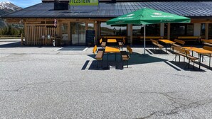 Un restaurant avec une terrasse, une vue sur la montagne et une enseigne indiquant « FILZSTEINalm ».