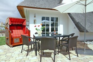 An outdoor patio with a table, chairs, and a wicker sofa. - Ferienhaus Weisse Dune, Zinnowitz (Zinnowitz)